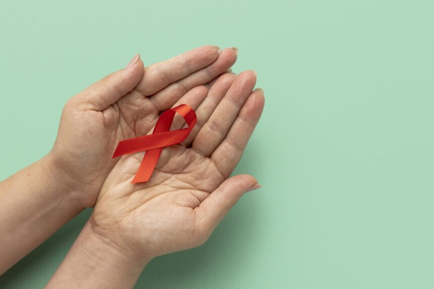 person holding world aids day ribbon scaled 1