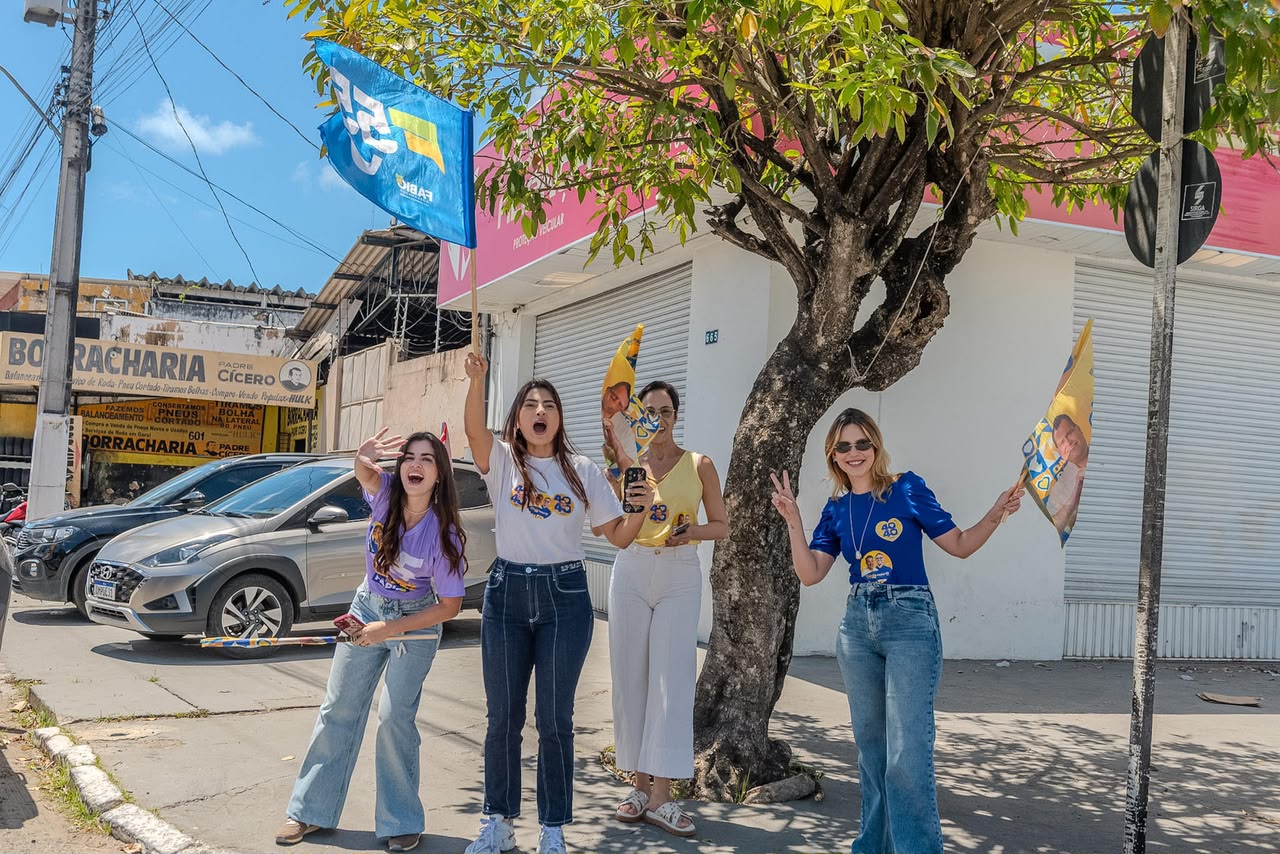 Moradora acena de janela durante a passagem da carreata em Aracaju